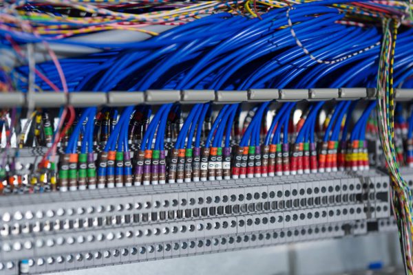 Blue wires feeding into a circuit board, technical Engineering imagery