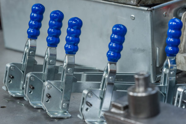 Stainless steel toggle clamp with blue handles manufactured by Sandfield Engineering
